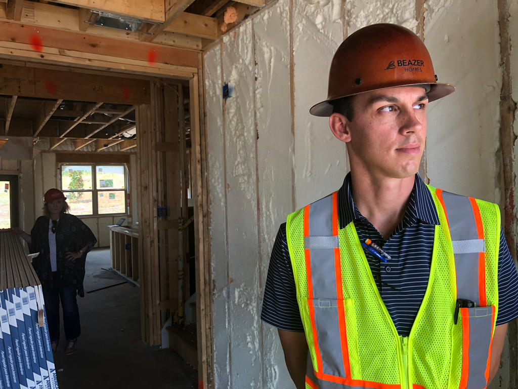 Beazer employee in hard hat standing in a home that is under construction