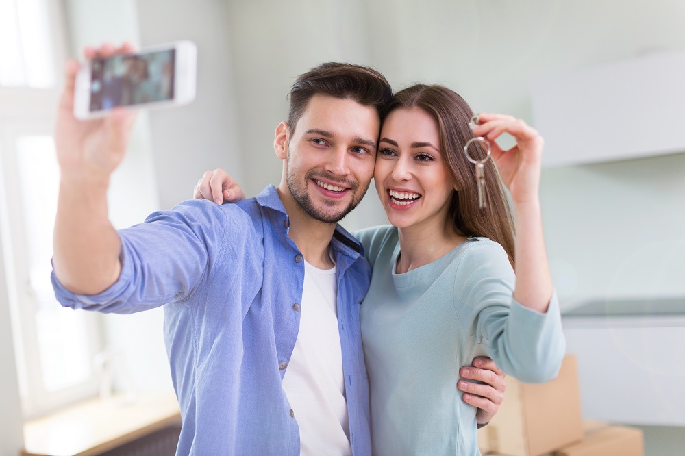 First time homeowners taking a photo with their keys